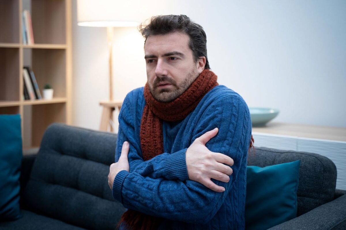 Man shivering in sweater at home