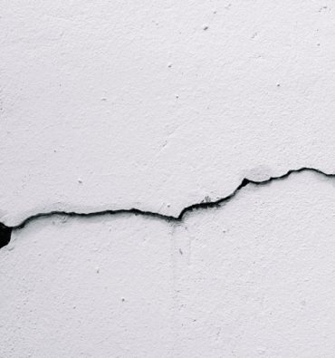 Cracks on the wall at the house or residence. The crack in the cement wall, Caused by the subsidence of the ground. Concrete wall crack background.